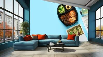 Containers with delicious food for delivery on blue background with space for text Wall mural