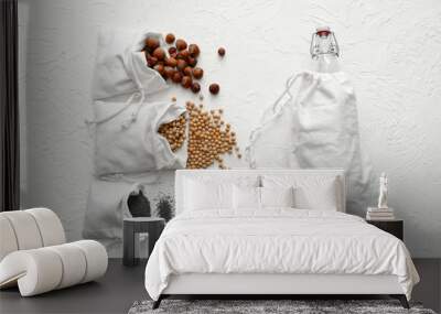 Cotton bags with fresh products and glass bottle on white background. Zero waste concept Wall mural