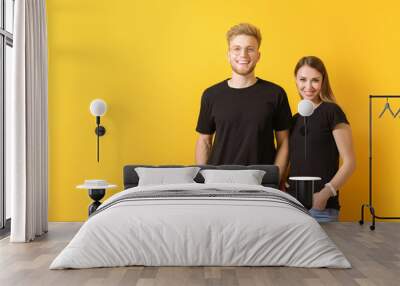 Couple in stylish t-shirts on color background Wall mural