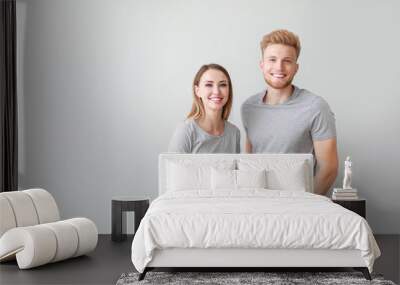 Couple in stylish t-shirts on light background Wall mural