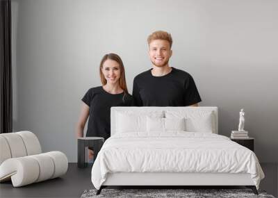 Couple in stylish t-shirts on light background Wall mural