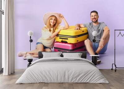 Couple with suitcases on color background Wall mural