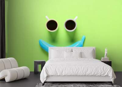 Creative composition with painted banana and cups of coffee on color background Wall mural