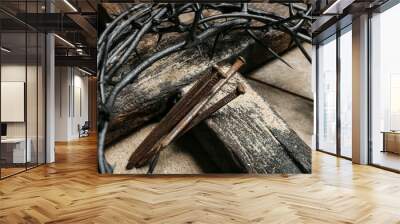 Crown of thorns with nails and cross on wooden background, closeup Wall mural