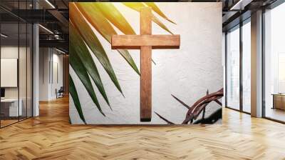 Crown of thorns with wooden cross and palm leaf on light background. Good Friday concept Wall mural