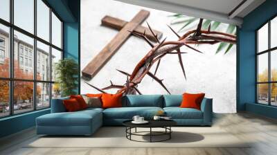 Crown of thorns with wooden cross and palm leaf on white grunge background, closeup. Good Friday concept Wall mural