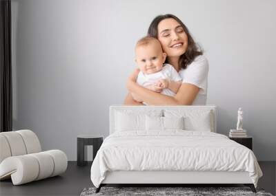 Cute baby with mother on light background Wall mural