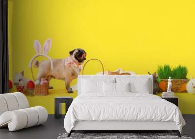 Cute fluffy rabbit with Easter eggs and basket on color background Wall mural