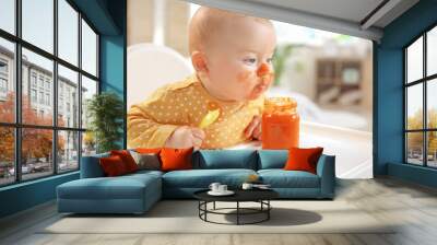 Cute little baby eating tasty food at home Wall mural