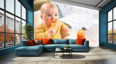 Cute little baby eating tasty food at home Wall mural