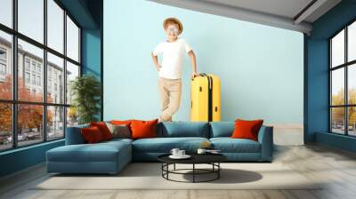 Cute little boy with suitcase near color wall Wall mural