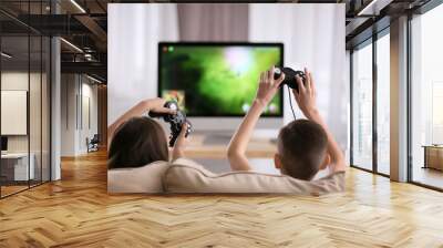 Cute little children playing computer game at home Wall mural