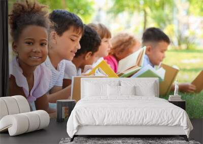 Cute little children reading books in park Wall mural