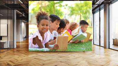 Cute little children reading books in park Wall mural