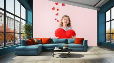 Cute little girl with pillow in shape of heart on color background. Valentines Day celebration Wall mural