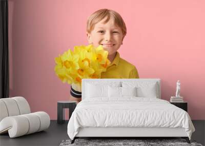 Cute little happy boy with bouquet of beautiful narcissus on pink background Wall mural