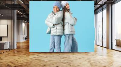 Cute little happy children in winter clothes on blue background Wall mural