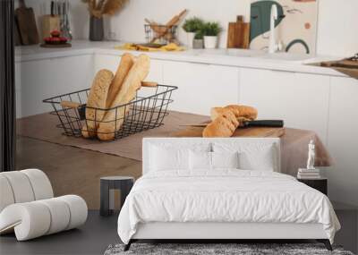 Cutting board with fresh baguette on table in interior of light kitchen Wall mural