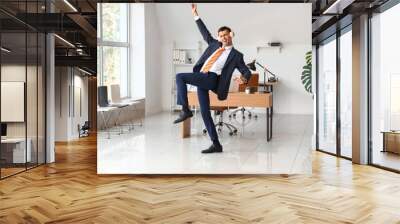 Dancing young businessman with headphones in office Wall mural