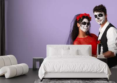 Dancing young couple dressed for Mexico's Day of the Dead (El Dia de Muertos) on lilac background with space for text Wall mural