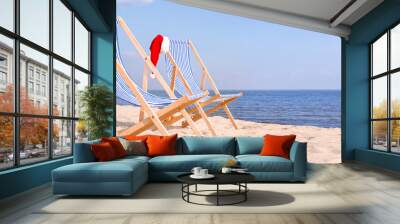 Deck chairs with Santa hats on sea beach Wall mural