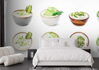 Delicious yogurt sauce with cucumber in bowls on white background Wall mural