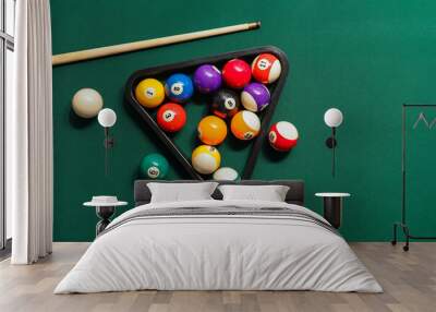 Different billiard balls with cue and rack on green table Wall mural