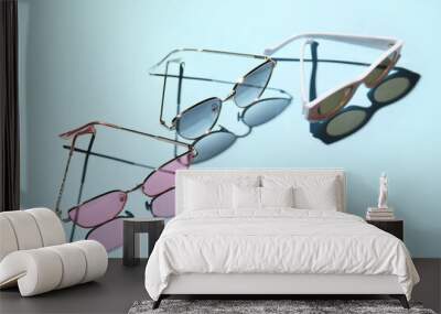 Different stylish sunglasses on blue background Wall mural