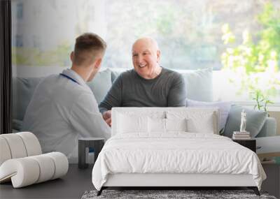 Doctor examining senior man in nursing home Wall mural