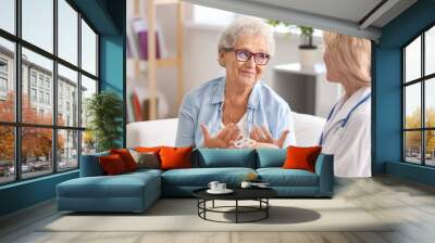 Doctor giving medicine to senior woman at home Wall mural