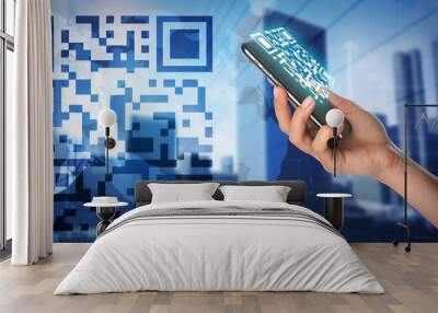 Double exposure of modern city and female hand holding smartphone with QR code on screen Wall mural