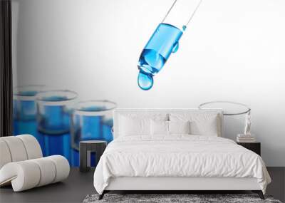 Dripping blue liquid into test tubes on white background Wall mural