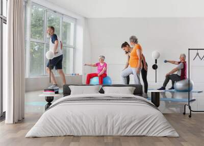 Elderly people training with instructor in gym Wall mural