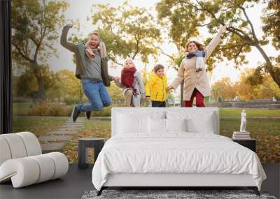 Family having fun in autumn park Wall mural