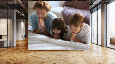 Family praying near bed at home Wall mural