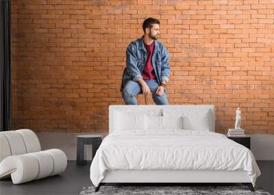 Fashionable young man near brick wall Wall mural