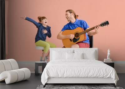 Father and daughter playing guitar near color wall Wall mural