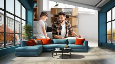 Father and son taking measures of wooden plank at home Wall mural