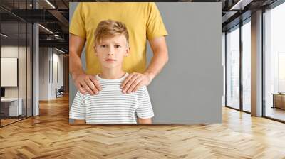 Father putting hands on shoulders of his scared son against grey background. Problem with communication between parent and child Wall mural