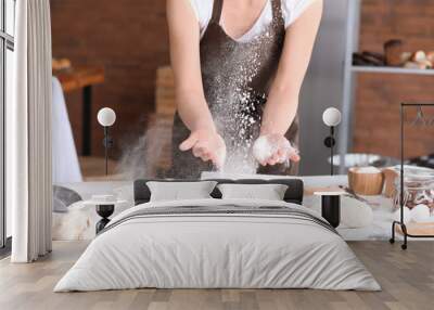 Female baker making dough in kitchen Wall mural