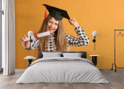 Female graduating student with diploma on color background Wall mural