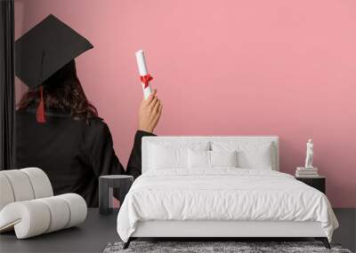 Female graduating student with diploma on pink background with space for text, back view Wall mural