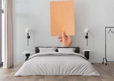 Female hand with blank paper on light background Wall mural