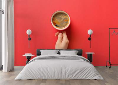 Female hand with cup of coffee on red background Wall mural