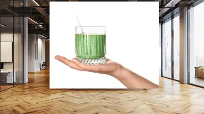 Female hand with glass of green smoothie on white background Wall mural