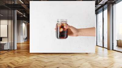 Female hand with mason jar of cold brew coffee on white background Wall mural