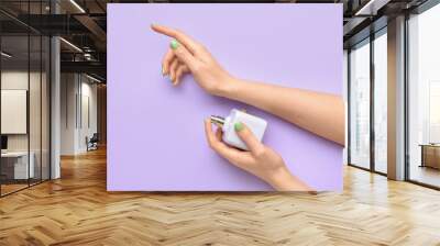 Female hand with perfume on color background Wall mural