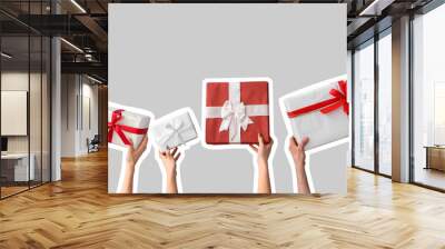 Female hands holding Christmas gift boxes on white background Wall mural