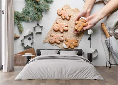 Female hands with gingerbread cookies on white background, top view Wall mural