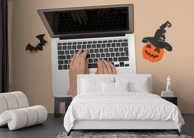 Female hands with modern laptop and decor for Halloween on color background Wall mural